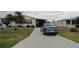 Charming single-story home with a well-maintained lawn, palm trees, and a concrete driveway at 6234 Parakeet Rd, Englewood, FL 34224