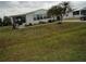 Well-maintained lawn with mature trees and landscaping, complemented by a home with large windows at 6234 Parakeet Rd, Englewood, FL 34224