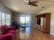 Bright living room with ceiling fan, hardwood floors, and sliding glass doors at 6234 Parakeet Rd, Englewood, FL 34224