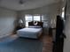Comfortable main bedroom featuring a ceiling fan, cozy decor, and three windows at 6234 Parakeet Rd, Englewood, FL 34224