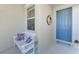 Front entry with blue door, white bench, and coastal decor at 9973 Holopaw St, Englewood, FL 34223