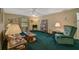 Living room with green carpet, wooden furniture, and lamps at 1402 Grand Blvd # 240, Sarasota, FL 34232