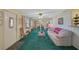 Living room features a beige sofa, green carpet, and a ceiling fan at 1402 Grand Blvd # 240, Sarasota, FL 34232