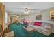 Living room features a beige sofa, green carpet, and mirrored closet doors at 1402 Grand Blvd # 240, Sarasota, FL 34232