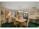 Bright dining room with wood table and chairs, green carpet, and views to living room at 1402 Grand Blvd # 240, Sarasota, FL 34232