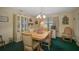 Charming dining room with wood table and chairs, green carpet, and built-in hutch at 1402 Grand Blvd # 240, Sarasota, FL 34232