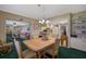 Dining room with wood table and chairs, green carpet, and kitchen views at 1402 Grand Blvd # 240, Sarasota, FL 34232
