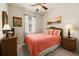 Guest bedroom with coral bedding, wicker furniture, and ceiling fan at 11723 Breadfruit Ln, Venice, FL 34292