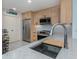 Modern kitchen with stainless steel sink, faucet, and a built-in cutting board at 147 Tampa E Ave # 202, Venice, FL 34285