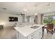 Kitchen island with sink, breakfast bar, and view into living room at 11925 Bohemian Pl, Venice, FL 34293