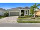 One-story house with green exterior and landscaped yard at 11925 Bohemian Pl, Venice, FL 34293