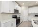 Modern kitchen with white cabinets, stainless steel appliances, and quartz countertops at 11925 Bohemian Pl, Venice, FL 34293