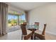 Casual dining area with glass-top table and wicker chairs, view to backyard at 11925 Bohemian Pl, Venice, FL 34293