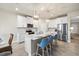 Open kitchen with white cabinets, island with seating, and stainless steel appliances at 11925 Bohemian Pl, Venice, FL 34293