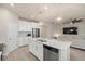 Modern kitchen with white cabinets, island, and stainless steel appliances at 11925 Bohemian Pl, Venice, FL 34293