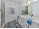 Modern bathroom with double vanity, walk-in shower, and wood-look floors at 121 Clifton Way, Venice, FL 34292