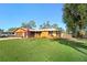 Eye-level view of a yellow house with American flag, grassy yard, and driveway at 1214 Laurel Ave, Venice, FL 34285