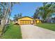 House exterior featuring a yellow-painted home with a well-maintained lawn and driveway at 1214 Laurel Ave, Venice, FL 34285