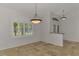 Open dining area featuring neutral tile flooring, plantation shutters, and modern light fixtures at 1219 Nantucket Rd, Venice, FL 34293