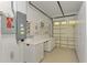 Garage with storage cabinets, built-in workbench, and open door to driveway at 1219 Nantucket Rd, Venice, FL 34293