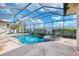 Enclosed pool and spa area featuring a rock waterfall and lush landscaping at 1219 Nantucket Rd, Venice, FL 34293