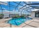 Enclosed pool with blue water and spa surrounded by lush, green landscaping at 1219 Nantucket Rd, Venice, FL 34293
