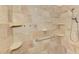 Modern tile shower with a shower head and soap and shampoo storage shelves at 1219 Nantucket Rd, Venice, FL 34293