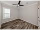 Cozy bedroom with modern ceiling fan, vinyl plank flooring, and natural light at 127 Nautical Dr, North Port, FL 34287