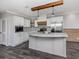 Modern kitchen boasts white cabinets, stainless steel appliances, marble countertops and backsplash and wood beam accents at 127 Nautical Dr, North Port, FL 34287