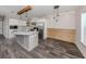 Modern kitchen boasts white cabinets, stainless steel appliances, marble countertops and backsplash and wood beam accents at 127 Nautical Dr, North Port, FL 34287
