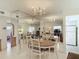 Bright dining room with oval table, chairs, and mirrored wall reflecting living room at 200 Park N Blvd # 103, Venice, FL 34285