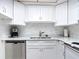 White kitchen with stainless steel dishwasher and marble countertops at 200 Park N Blvd # 103, Venice, FL 34285