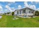 White manufactured home with a large screened porch and canal view at 472 Sharks Pt, North Port, FL 34287