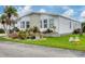 White single-wide manufactured home with landscaped yard and carport at 472 Sharks Pt, North Port, FL 34287