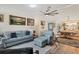 Open concept living and dining area with gray sofas and hardwood floors at 472 Sharks Pt, North Port, FL 34287