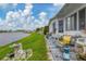 White manufactured home with patio furniture and bird bath overlooking canal at 472 Sharks Pt, North Port, FL 34287