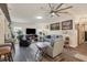 Living area with gray sectional sofa, built-in shelving and hardwood floors at 472 Sharks Pt, North Port, FL 34287