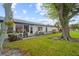 Spacious backyard with patio furniture and large shade tree at 605 Apple Ln, Englewood, FL 34223