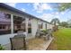 Concrete patio with gray table and chairs, next to grass at 605 Apple Ln, Englewood, FL 34223