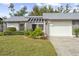 Charming condo with gray roof, white garage door, and well-manicured lawn at 605 Apple Ln, Englewood, FL 34223