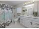 Clean bathroom with white vanity and a floral shower curtain at 1141 Sleepy Hollow Ct, Venice, FL 34285
