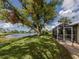 Spacious backyard with water views and screened enclosure at 1141 Sleepy Hollow Ct, Venice, FL 34285