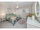 Bedroom with floral bedding, a wicker chair, and a vanity at 1141 Sleepy Hollow Ct, Venice, FL 34285