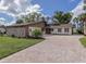 Charming two-story home with a stone facade, updated landscaping, and paved driveway at 1141 Sleepy Hollow Ct, Venice, FL 34285