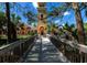 Wooden footbridge leading to community clubhouse with bell tower at 150 Bella Vista Ter # 15B, Nokomis, FL 34275