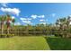 Grass lawn, palm trees, and a lake view in a sunny Florida setting at 150 Bella Vista Ter # 15B, Nokomis, FL 34275