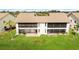 Back exterior view of two-story condo with screened patio and grassy yard at 1743 Lake Pl # 1743C, Venice, FL 34293