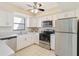 Kitchen with white cabinets, stainless steel appliances, and gray countertops at 1743 Lake Pl # 1743C, Venice, FL 34293