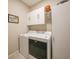 Convenient laundry room with washer, dryer, and overhead cabinets at 19313 Yellowtail Ct, Venice, FL 34292