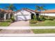 Single-story home with a white garage door and landscaped front yard at 24057 Spartina Dr, Venice, FL 34293